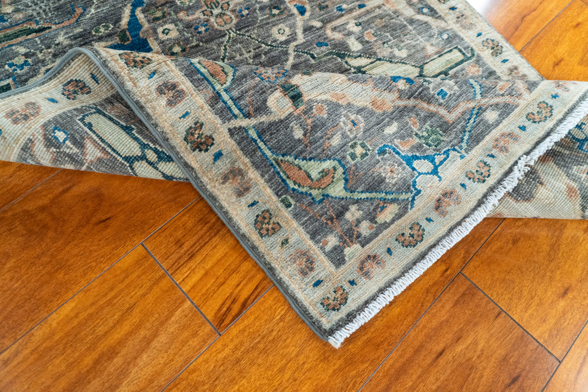 Folded corner of the Farahan Afghan runner showing the hand-knotted back and beige border