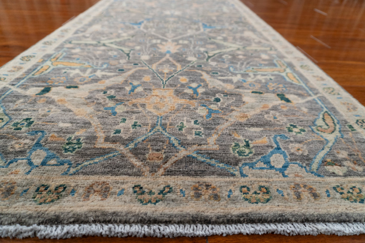 Low angle view along the Farahan runner toward the end, showing charcoal field with peach and blue vines